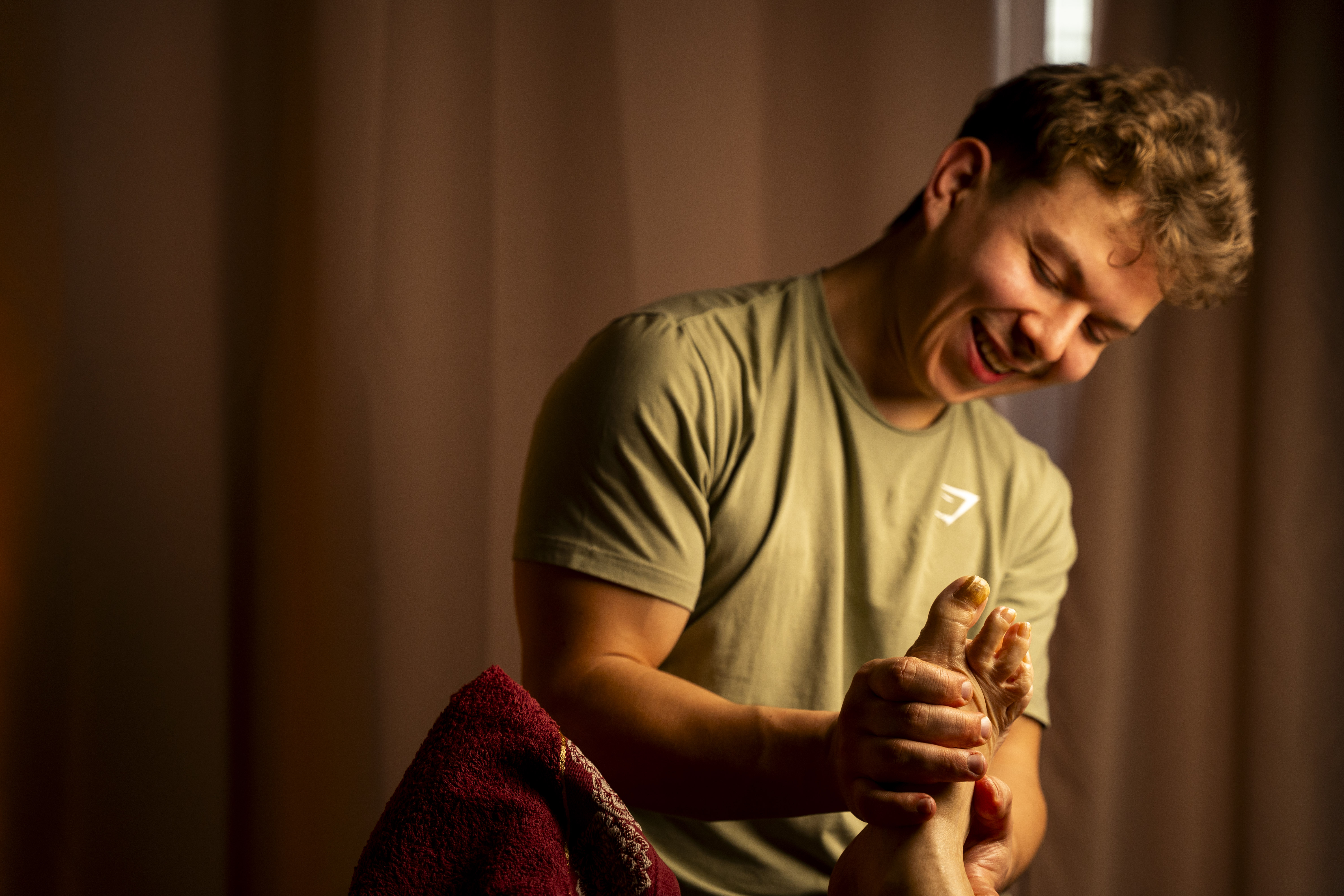 Masseur travaillant les zones réflexes sous le pied d'un client