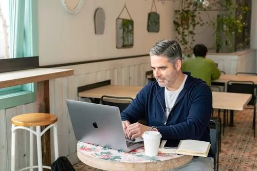 A salesperson working in an cafe/coffee shop on a virtual call