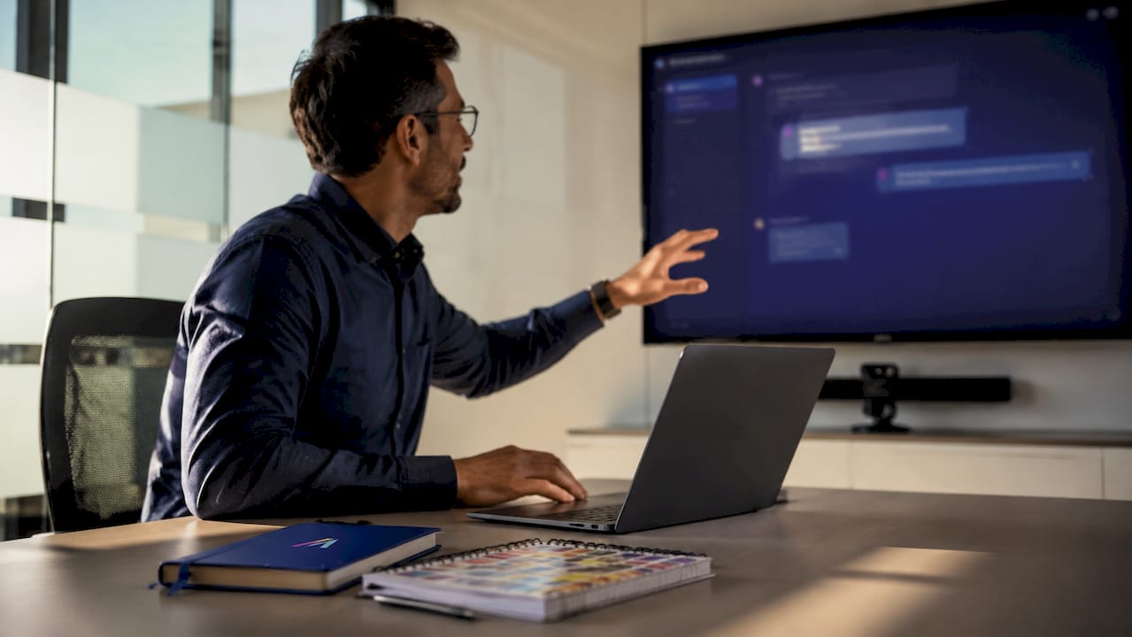 Person interacting with AI on laptop in office