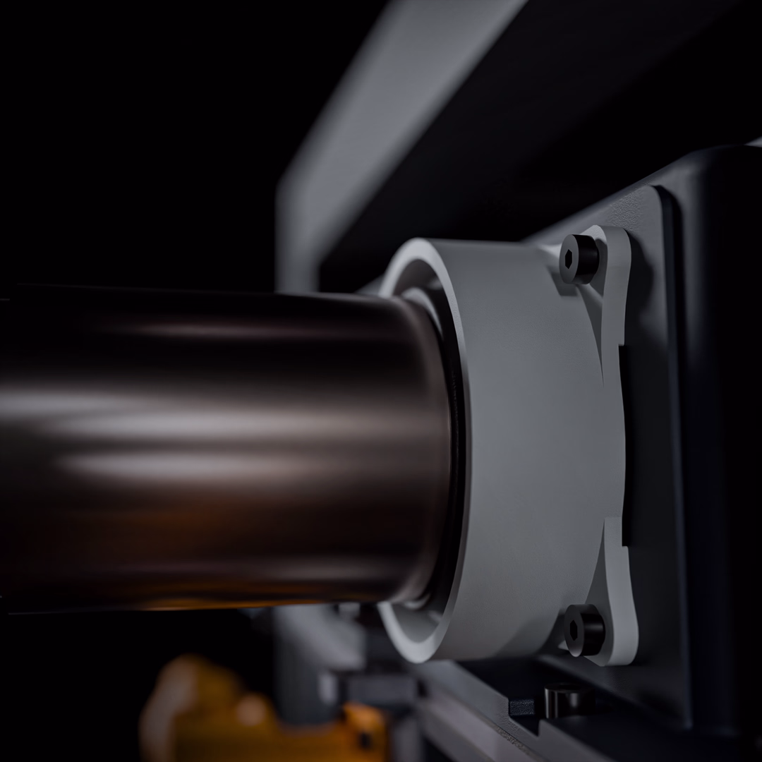 Close-up of a modern metallic cylindrical part attached to a mechanical device with screws.