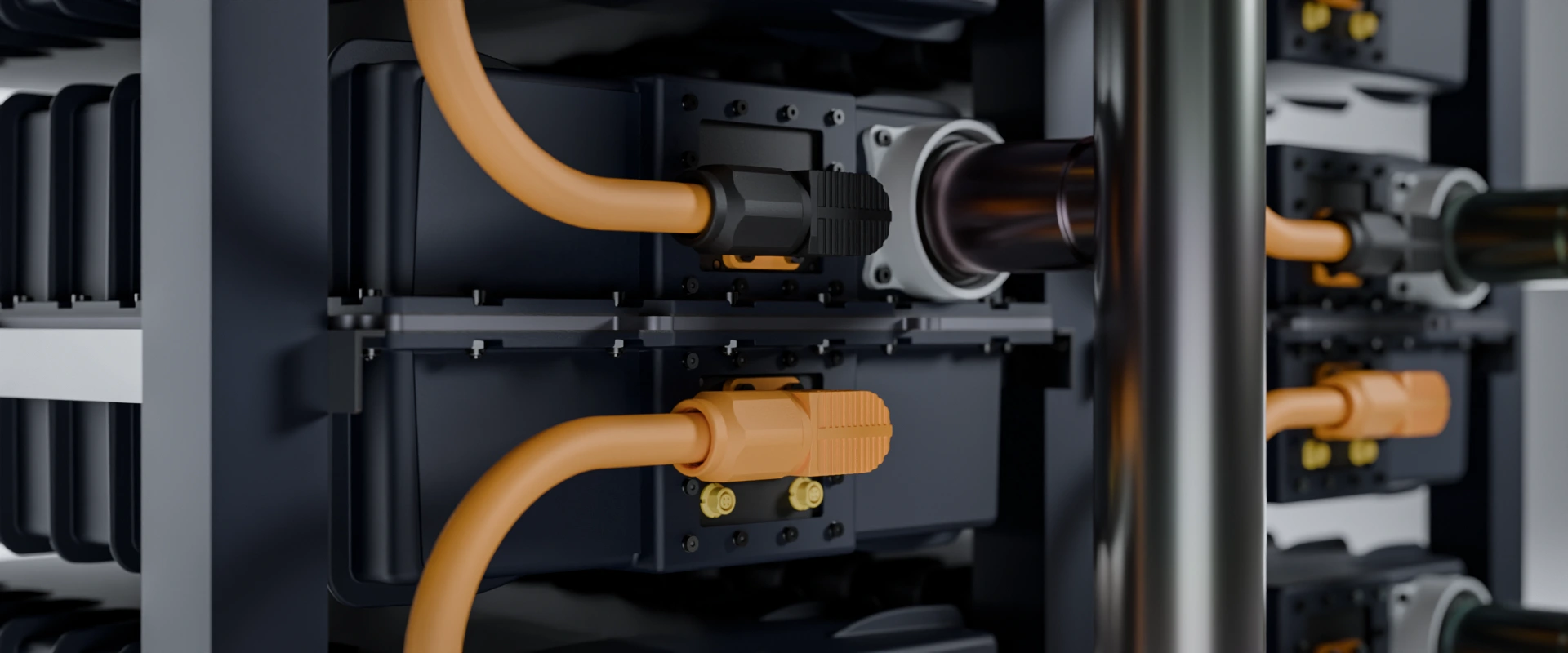 Close-up of black and orange cables connected to dark electronic equipment with metal pipes.