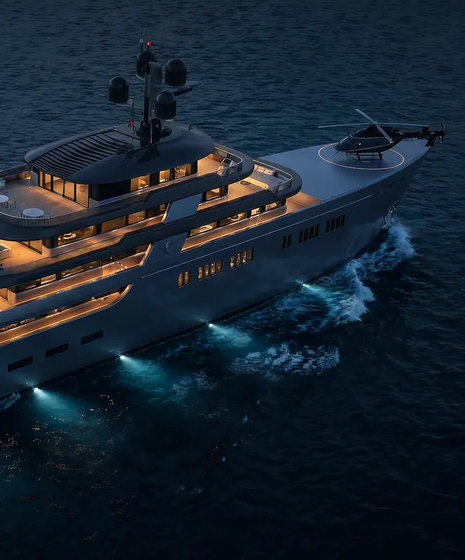 Luxury yacht cruising on dark water at night with deck lights and helicopter on bow.