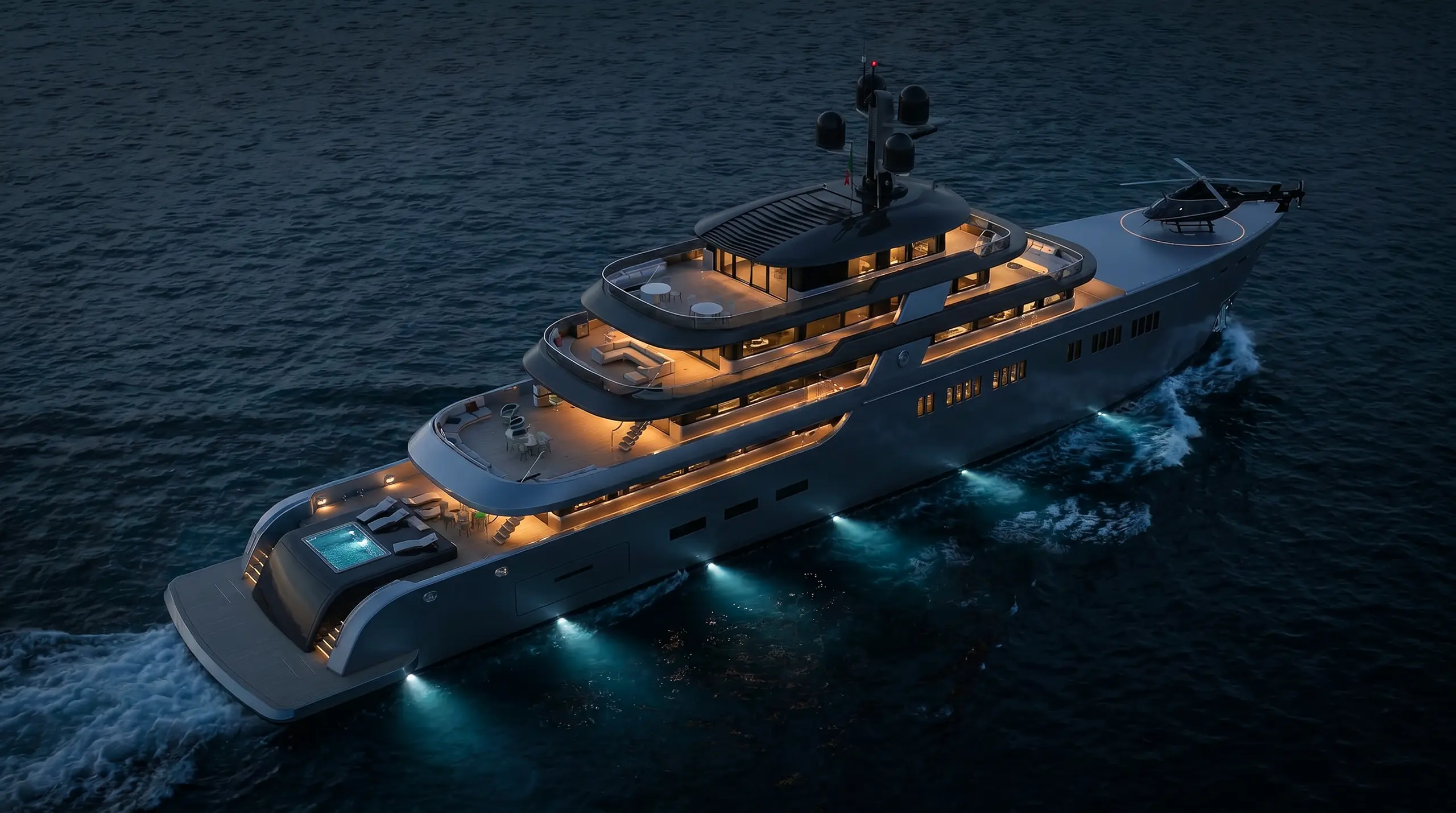 Luxury yacht cruising on dark water at night with deck lights and helicopter on bow.