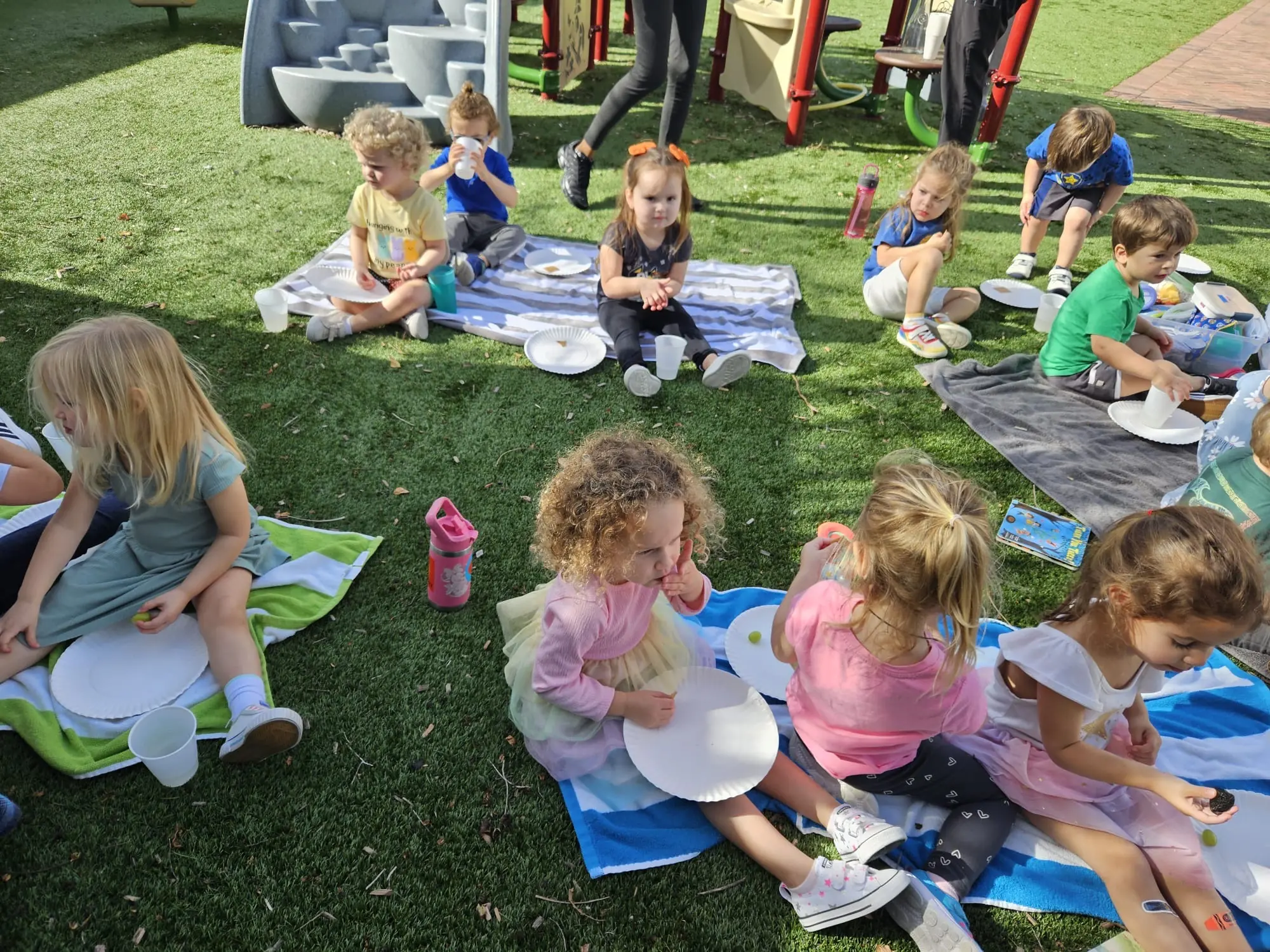 Young children enjoying an outdoor picnic and social activity during JCC hours and preschool programs