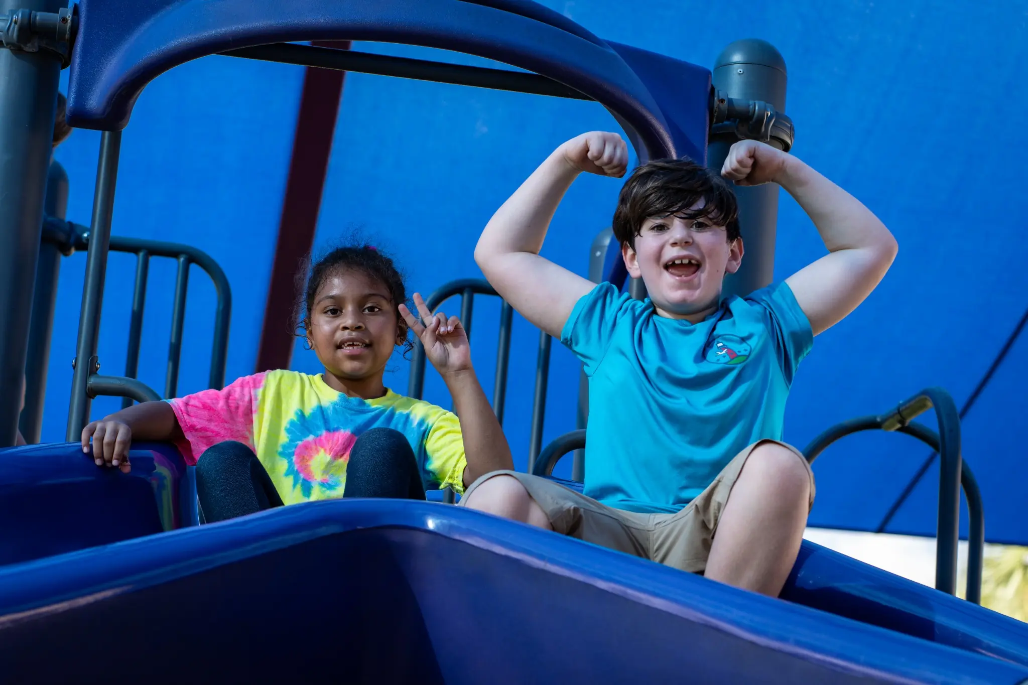 Children enjoying outdoor playtime on a playground slide during JCC classes and youth enrichment programs
