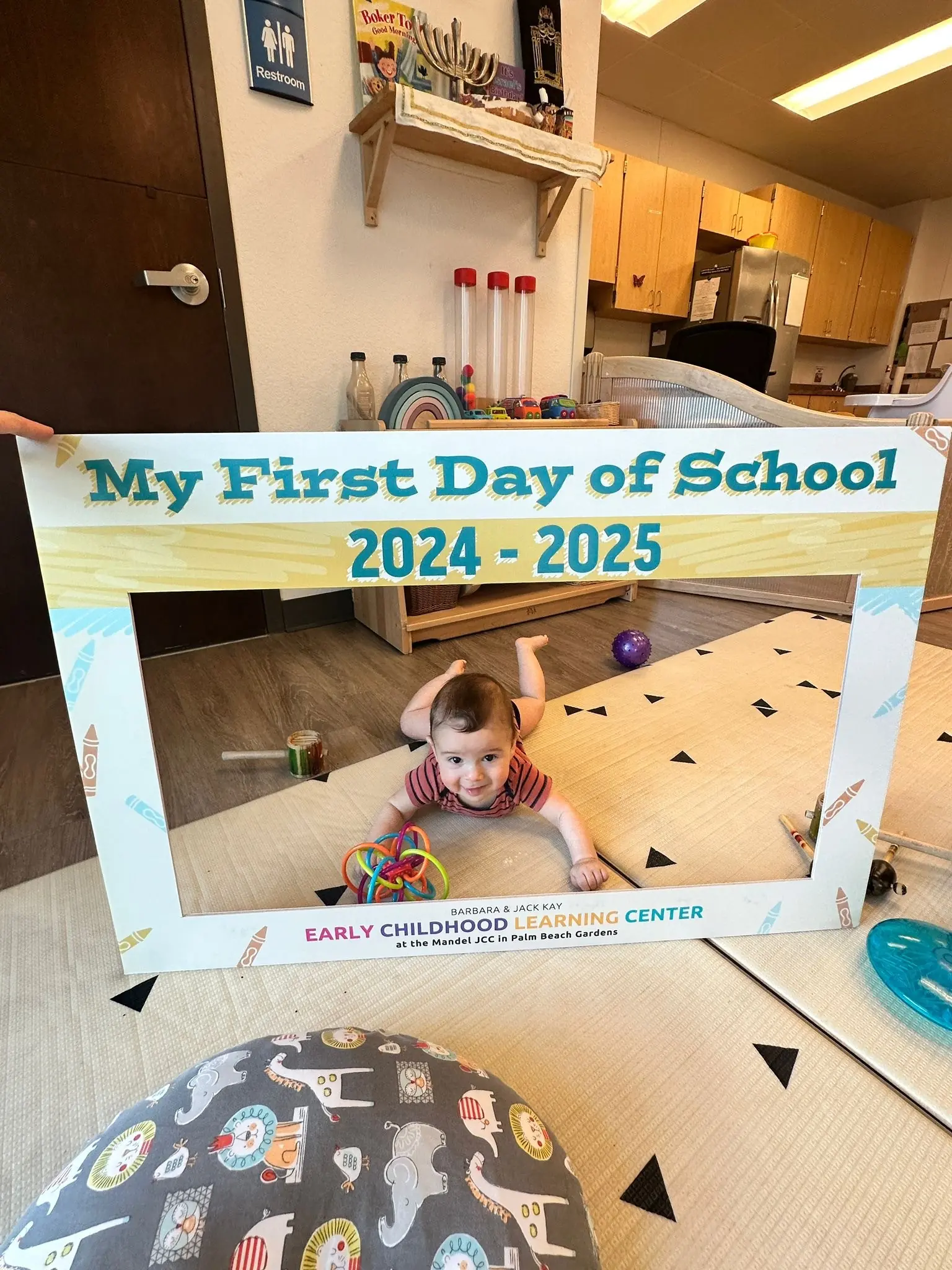 Infant celebrating the first day of school at a JCC early childhood learning center