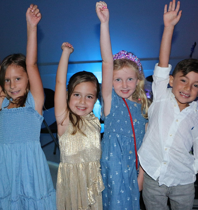 preschoolers with arms raised in camaraderie at Boynton Beach Early Childhood Learning Center