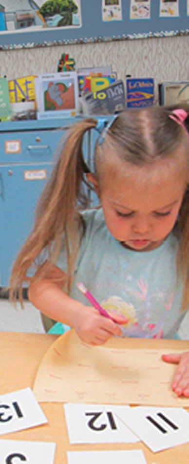 two year old practices writing numbers in structured learning at preschool boynton beach fl