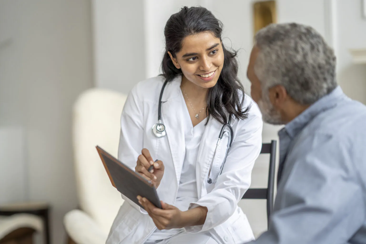 Doctor with a tablet consulting an older patient, representing access to NCH experts through Nina."