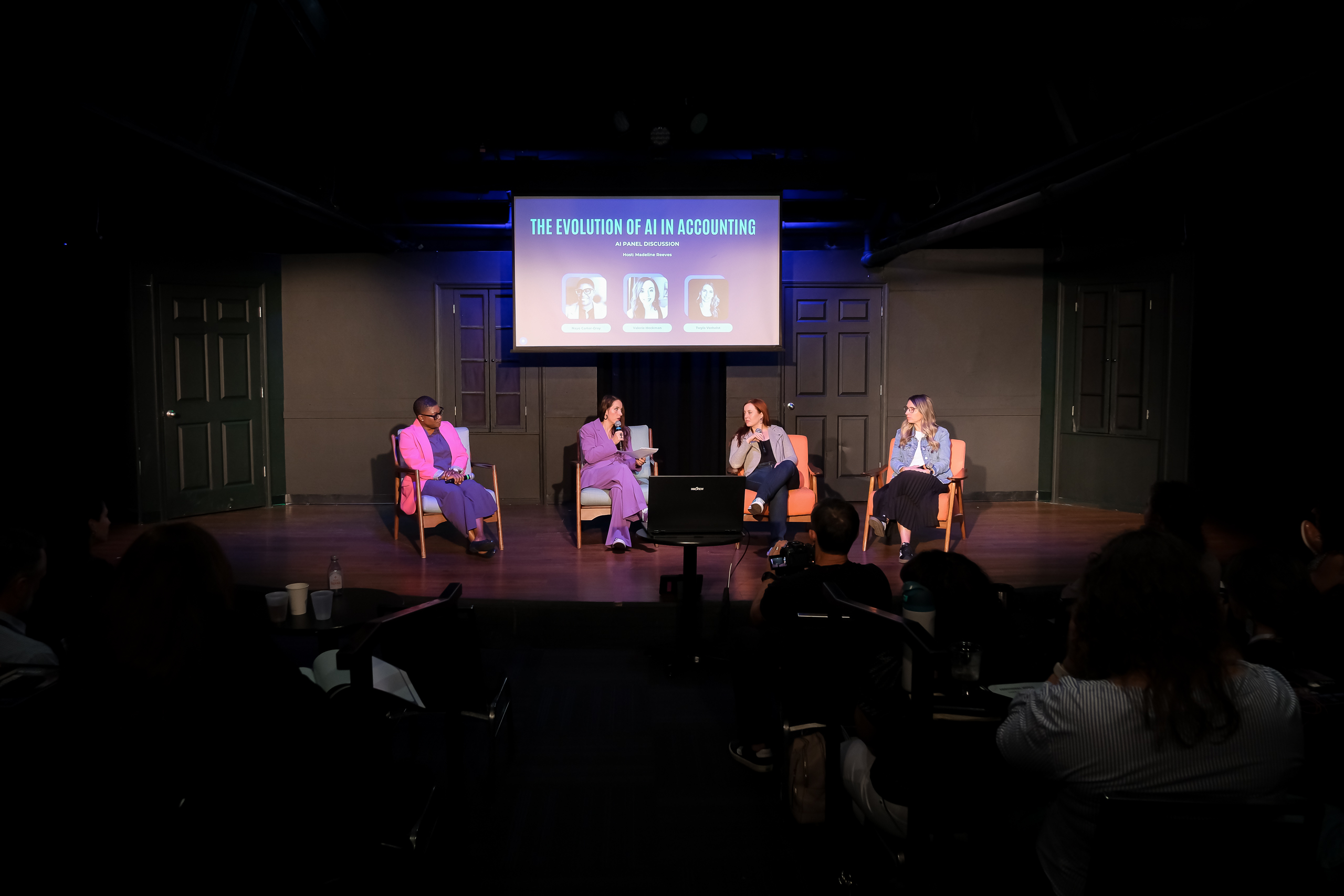 Panel discussion titled 'The Evolution of AI in Accounting' with four women seated on stage in armchairs speaking to an audience.
