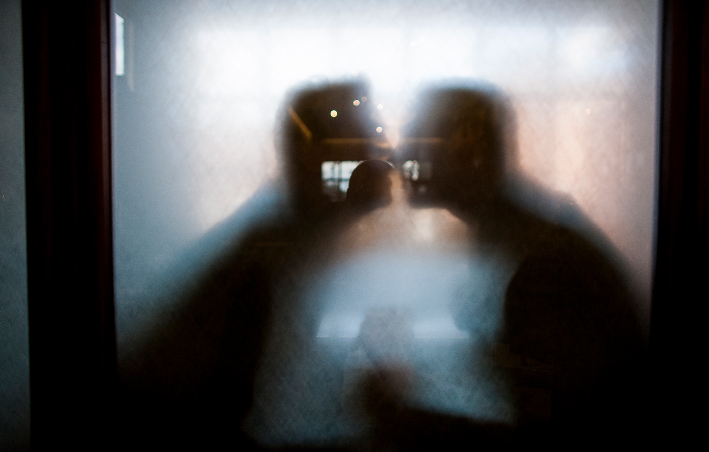 Obscured photo of couple kissing behind frosted glass Kunde Winery