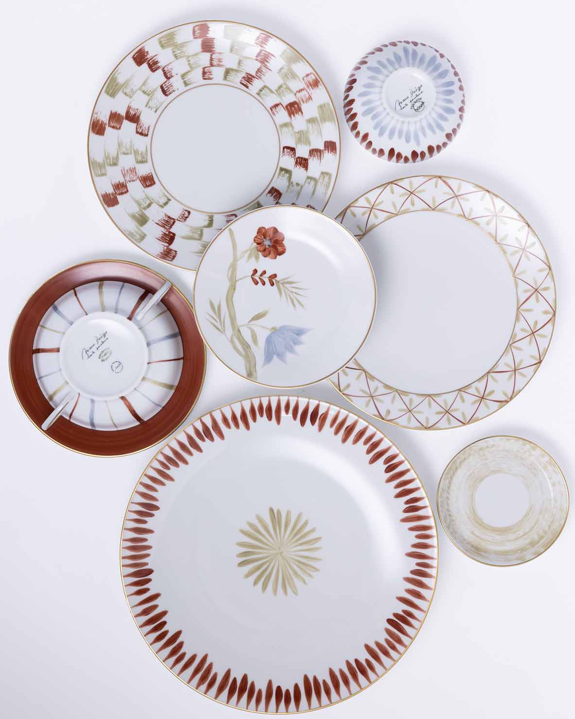 Set of seven decorative plates with various floral and geometric patterns in red, green, gold, and blue tones.