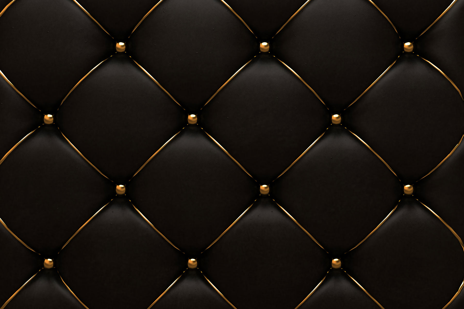Close-up of black leather upholstery with diamond tufting and gold buttons.