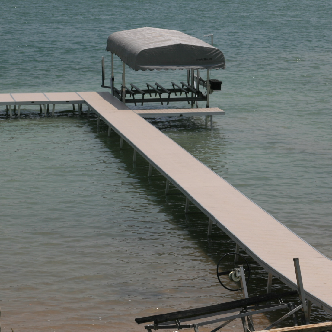Long white dock extending into a calm Michigan lake