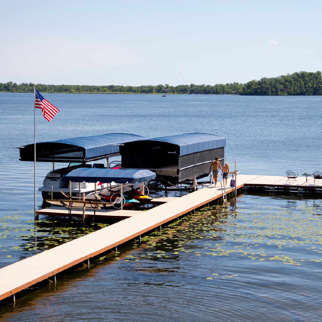 Pontoon boat on a canopy boat lift beside a residential dock