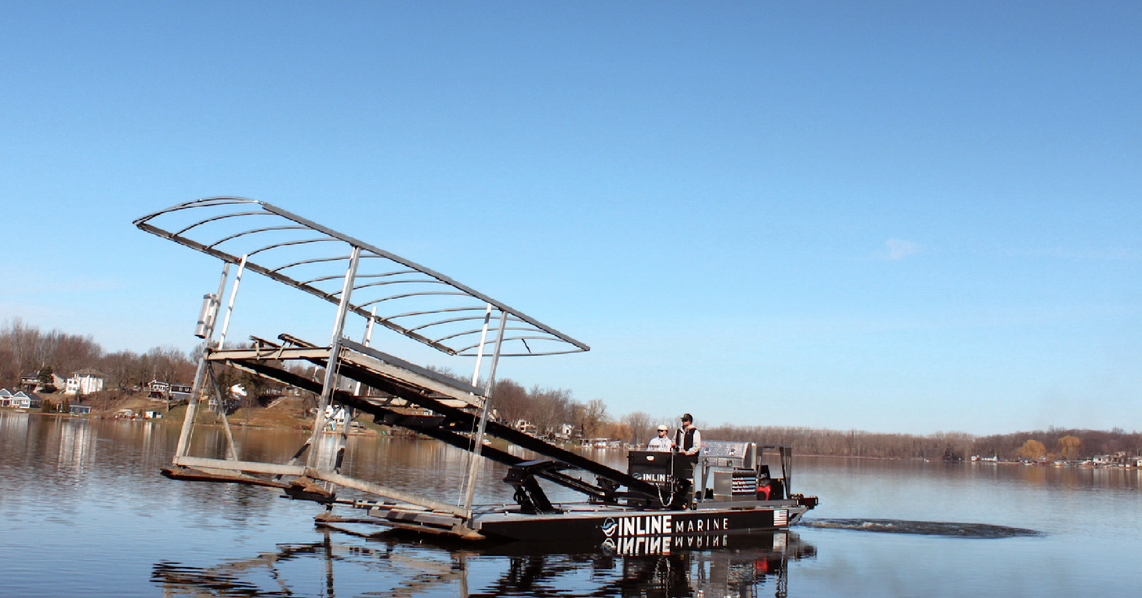 Inline Marine fork barge transporting a boat lift across a lake