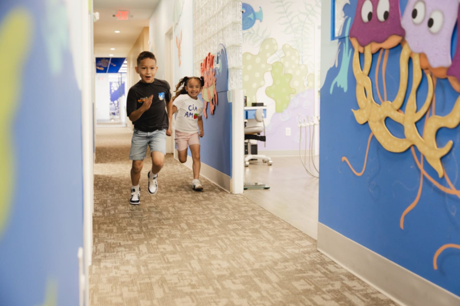 Colorful hallway with blue and purple walls and artwork at pediatric dental practice