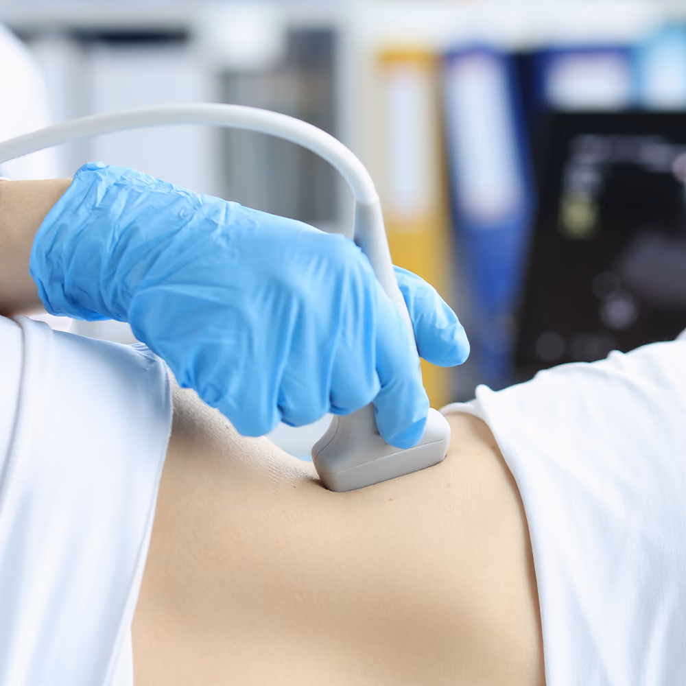 Healthcare professional performing a liver ultrasound examination on a patient's abdomen to assess liver health in a clinical setting.