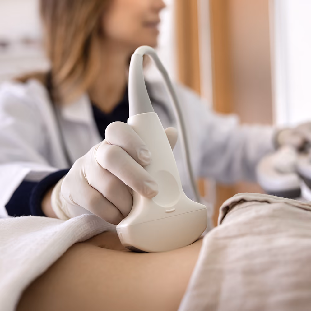 Healthcare professional performing a liver ultrasound scan on a patient's abdomen during a non-invasive liver assessment.