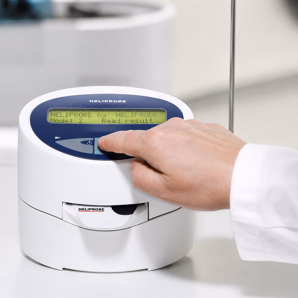 Healthcare professional preparing a Helicobacter pylori breath test device to assess a patient for H. pylori infection.