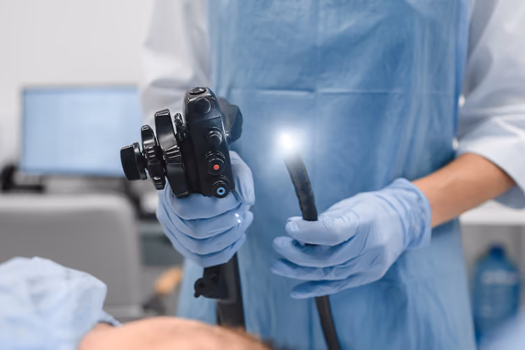 Healthcare professional holding a gastroscope before performing a gastroscopy procedure in a clinical setting.