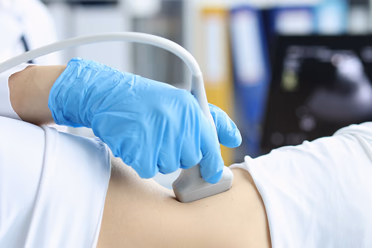 Healthcare professional performing a FibroScan liver scan with an ultrasound probe to assess liver stiffness and health.