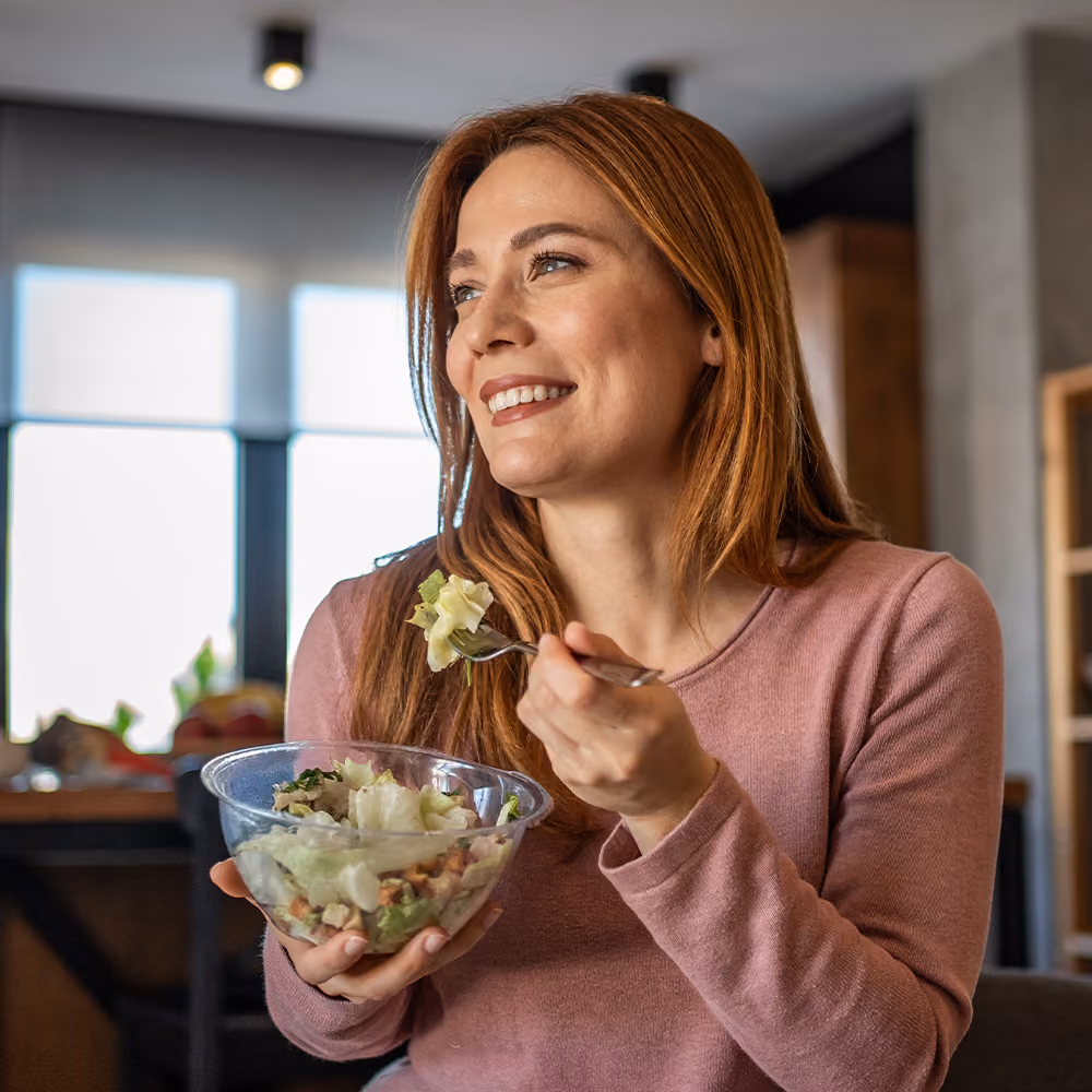 Person enjoying a healthy salad as part of a balanced diet before an iron infusion procedure.