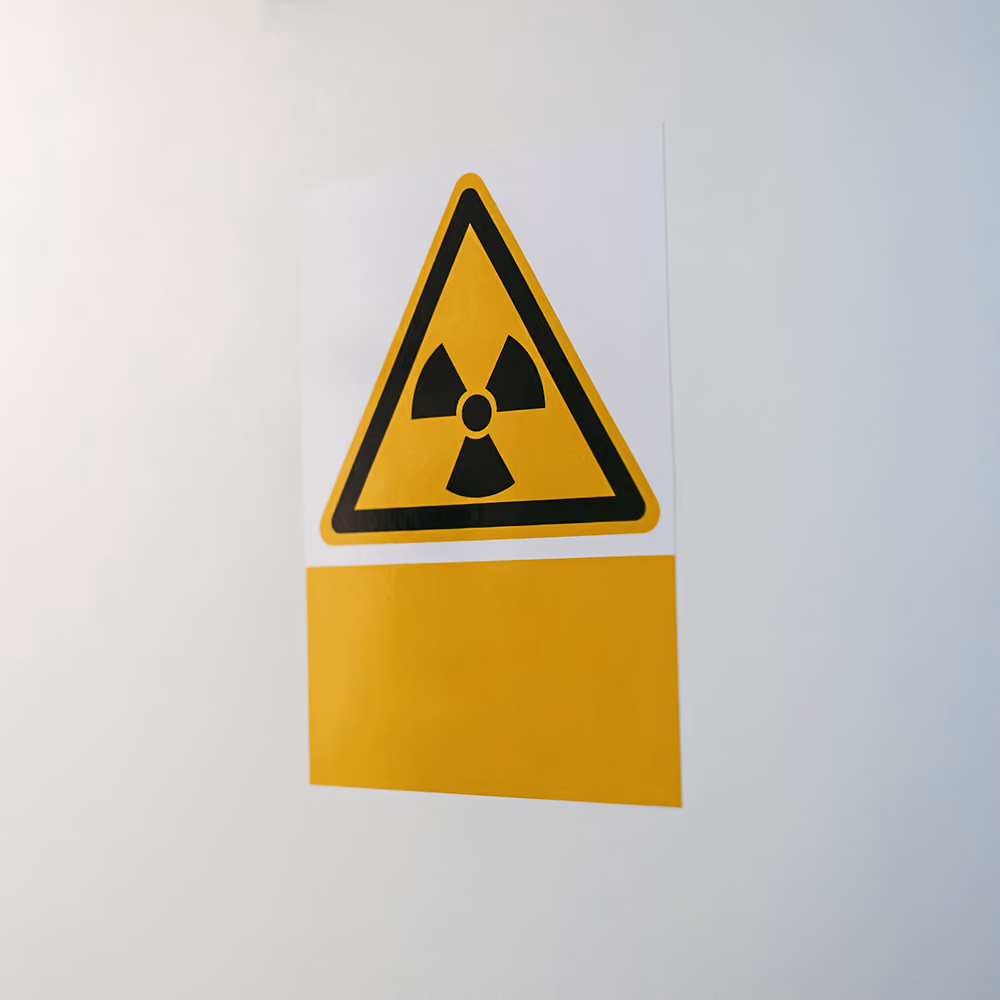 Radiation safety sign displayed on a clinic door, indicating a controlled area where radiation is used during medical imaging procedures.