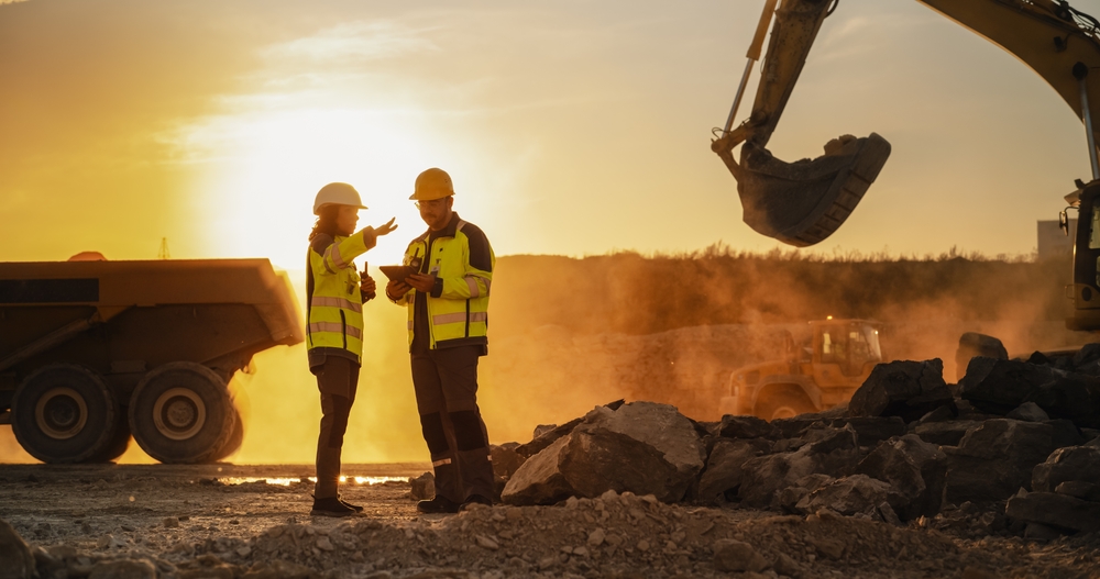 Trucks and excavators moving earth at a construction site