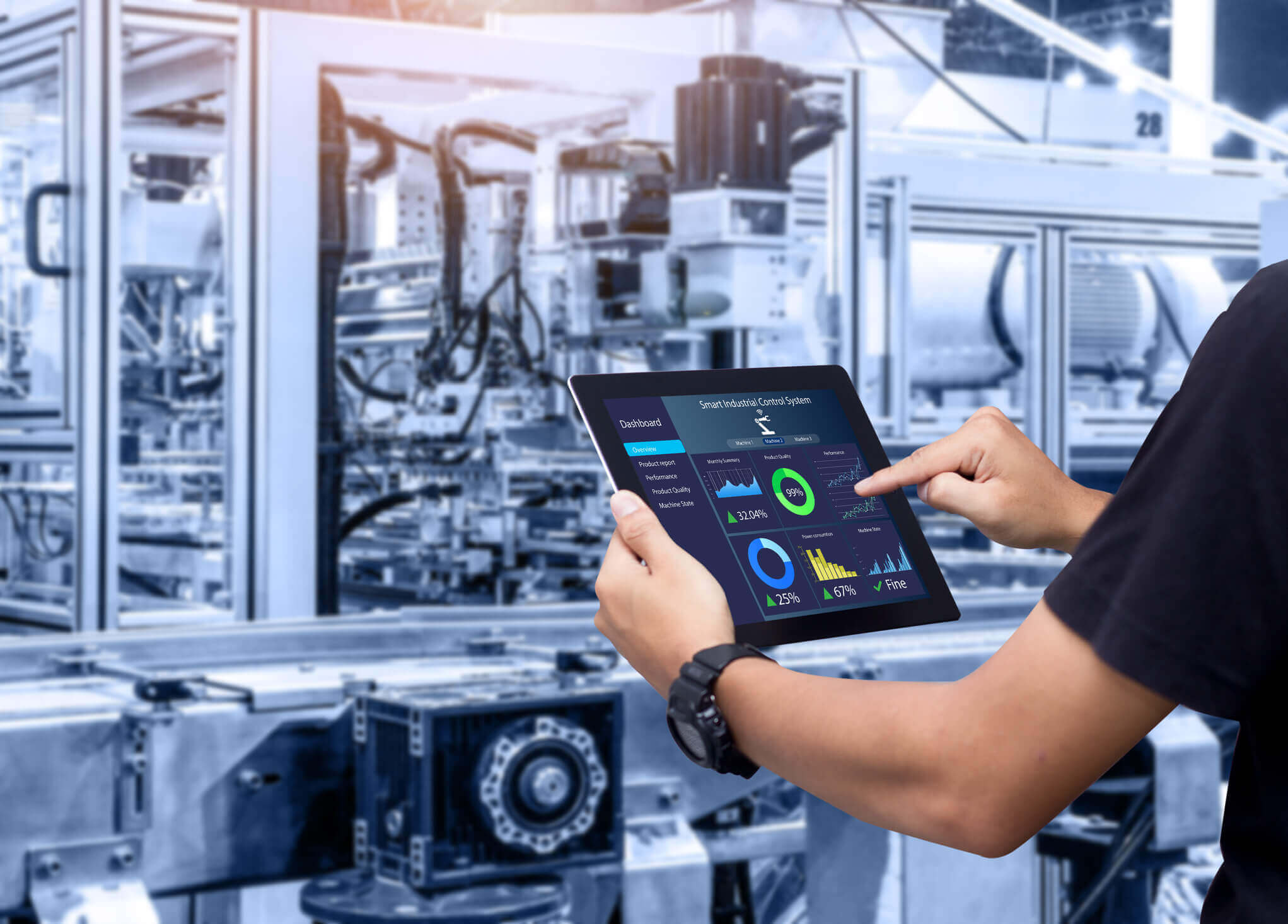 Person holding a tablet displaying a smart industrial control system dashboard with charts and performance metrics in an automated manufacturing facility.