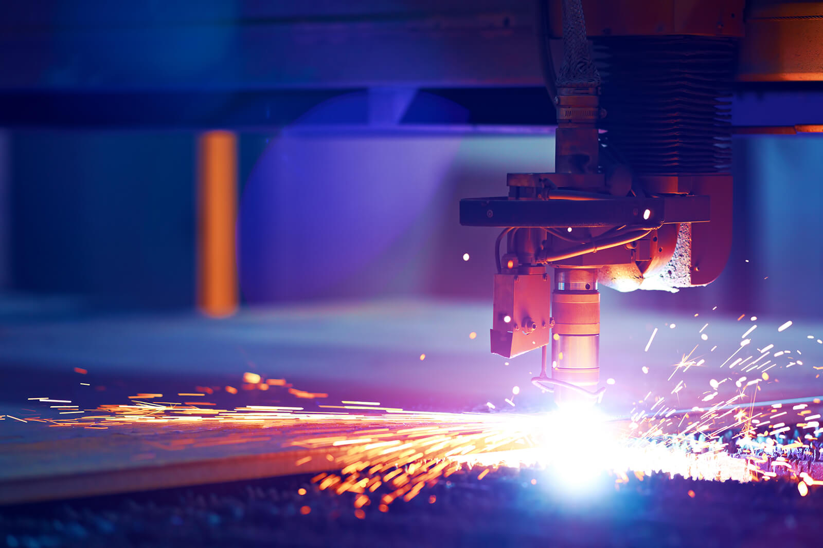 Close-up of a CNC plasma cutting machine cutting through metal, producing bright sparks and glowing light.