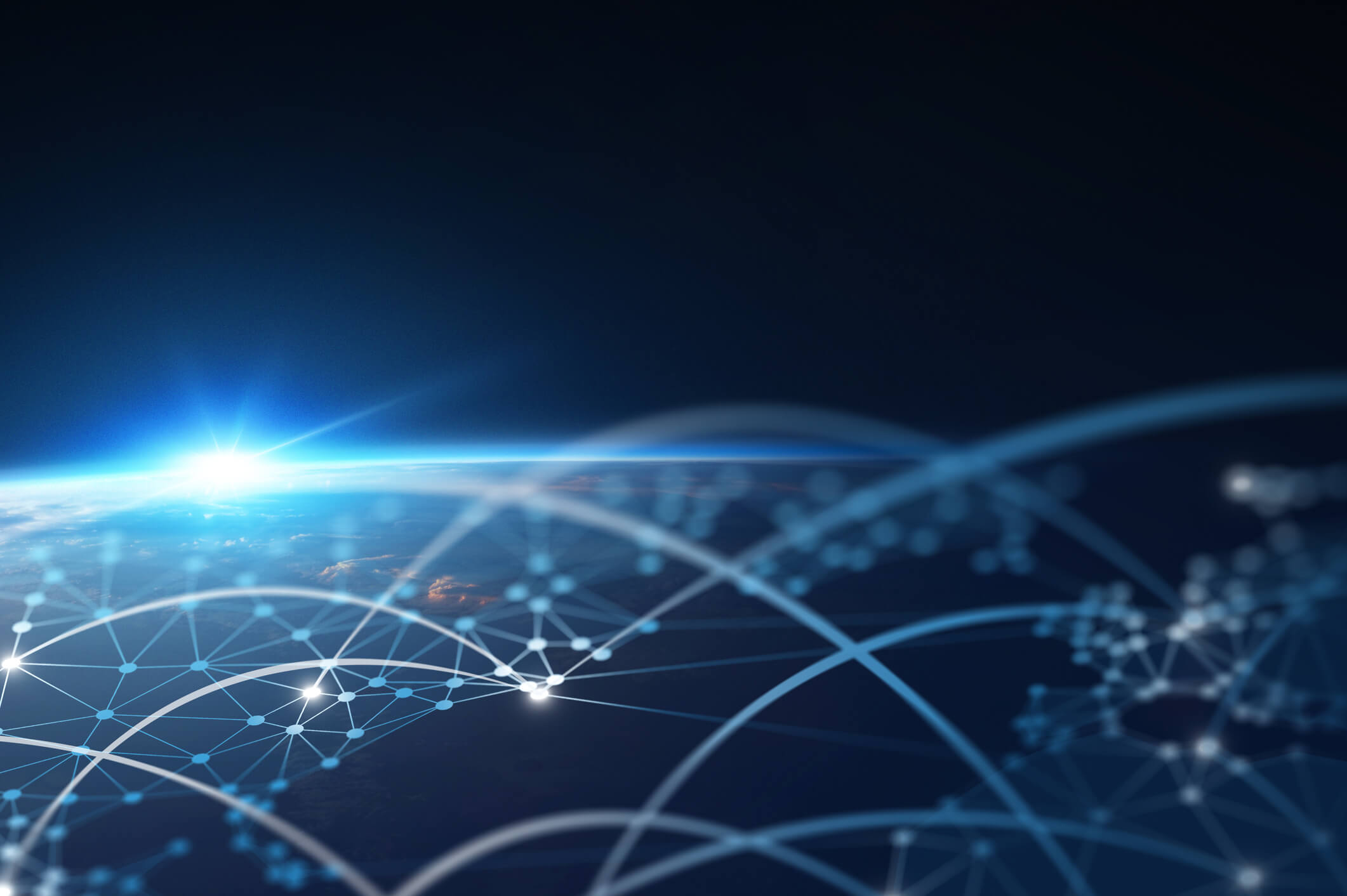View of Earth from space at sunrise with a digital network overlay of connected nodes and arcs symbolizing global communication or data exchange.