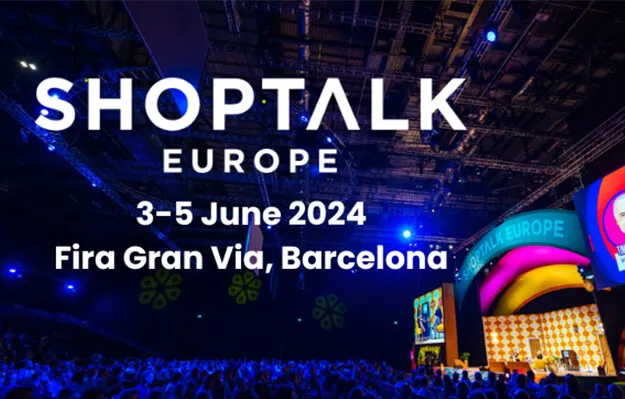 A large crowd attending Shoptalk Europe 2024 at Fira Gran Via, Barcelona, with a stage lit by blue and purple lights and a large screen displaying colorful visuals.
