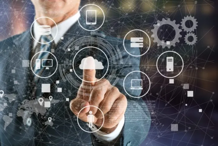 Businessman in suit interacting with a digital interface displaying cloud computing and various technology icons such as servers, devices, and gears, symbolizing enterprise service management and IT connectivity.