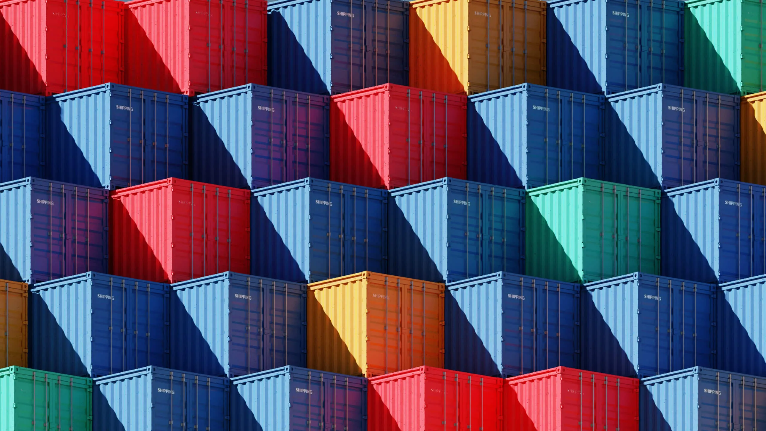 A tightly stacked arrangement of colorful shipping containers in red, blue, green, orange, and yellow creating a geometric pattern with shadows.