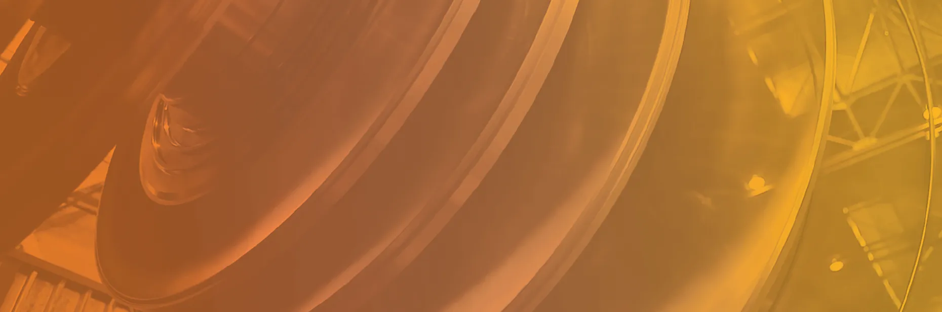 Abstract close-up of a glossy, curved surface with reflections and a warm orange-yellow gradient filter.