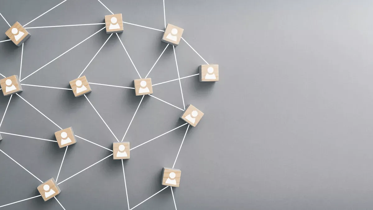 Wooden blocks with white person icons connected by white lines on a gray background, representing a social or network connection concept.