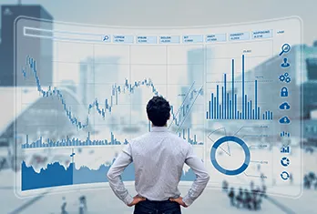 Man standing with hands on hips facing a large transparent digital screen displaying various financial charts, graphs, and icons in a cityscape background.