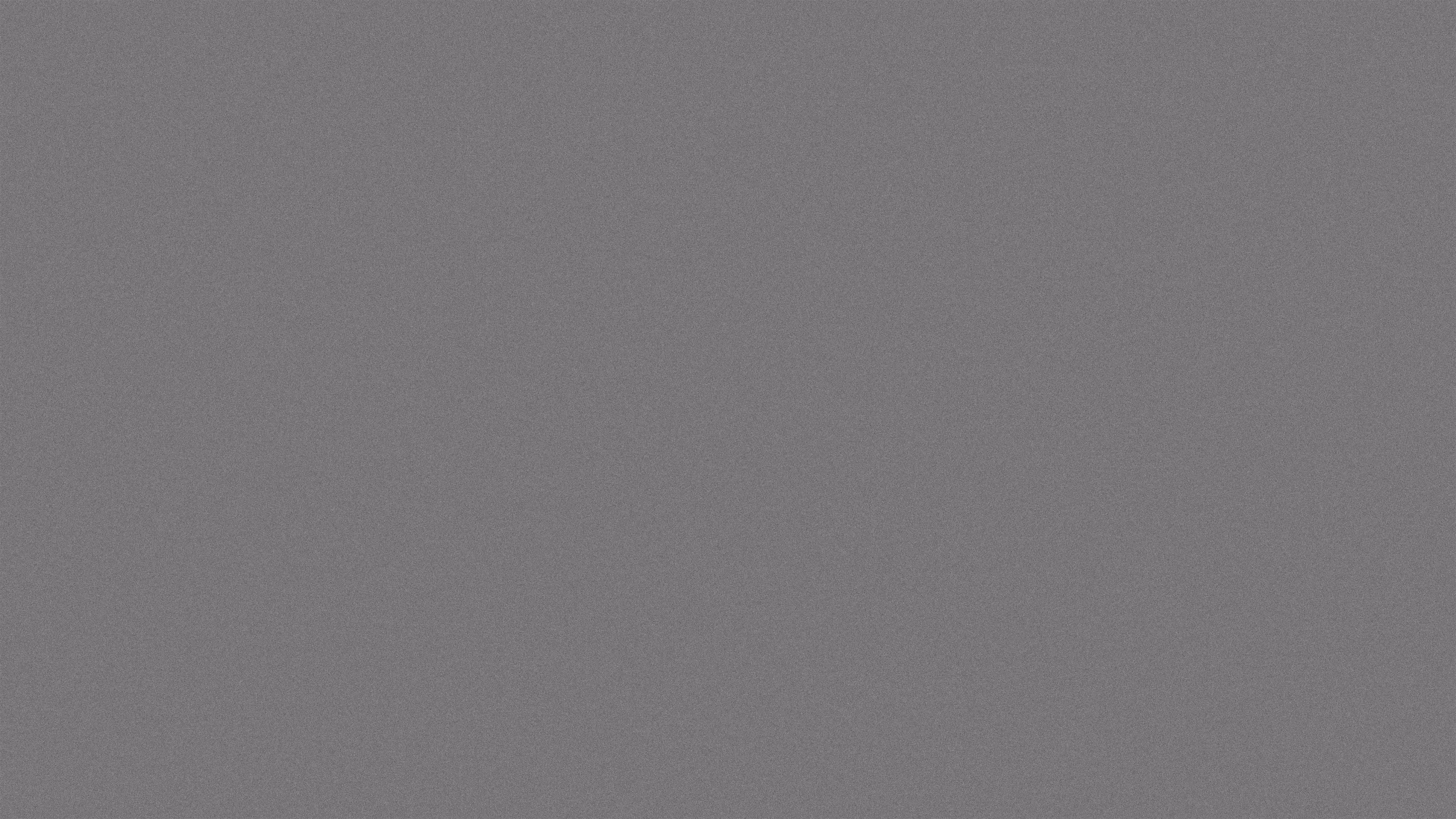 Grey film grain texture background with a subtle noise pattern.