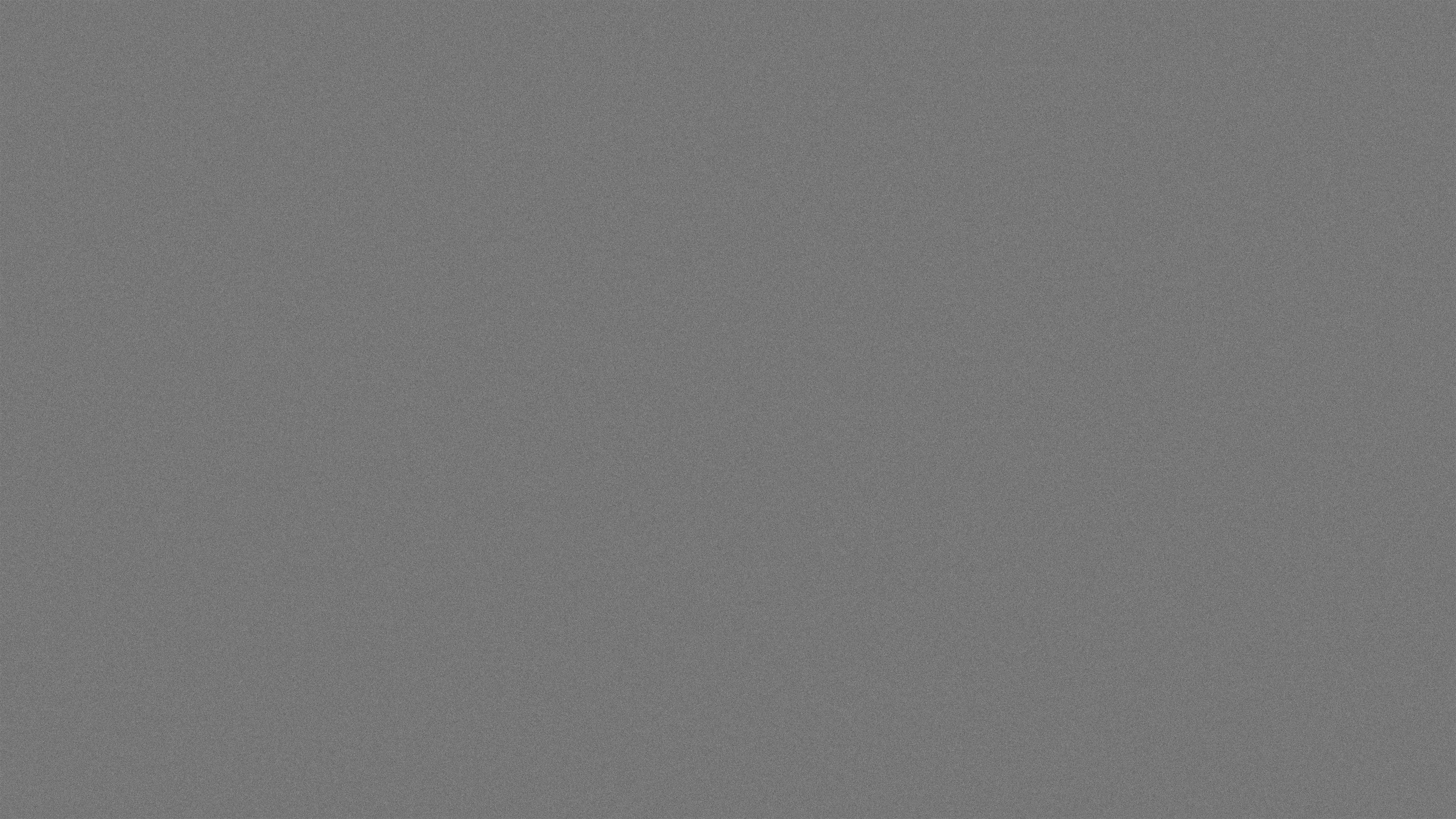 Grey film grain texture background with a subtle noise pattern.
