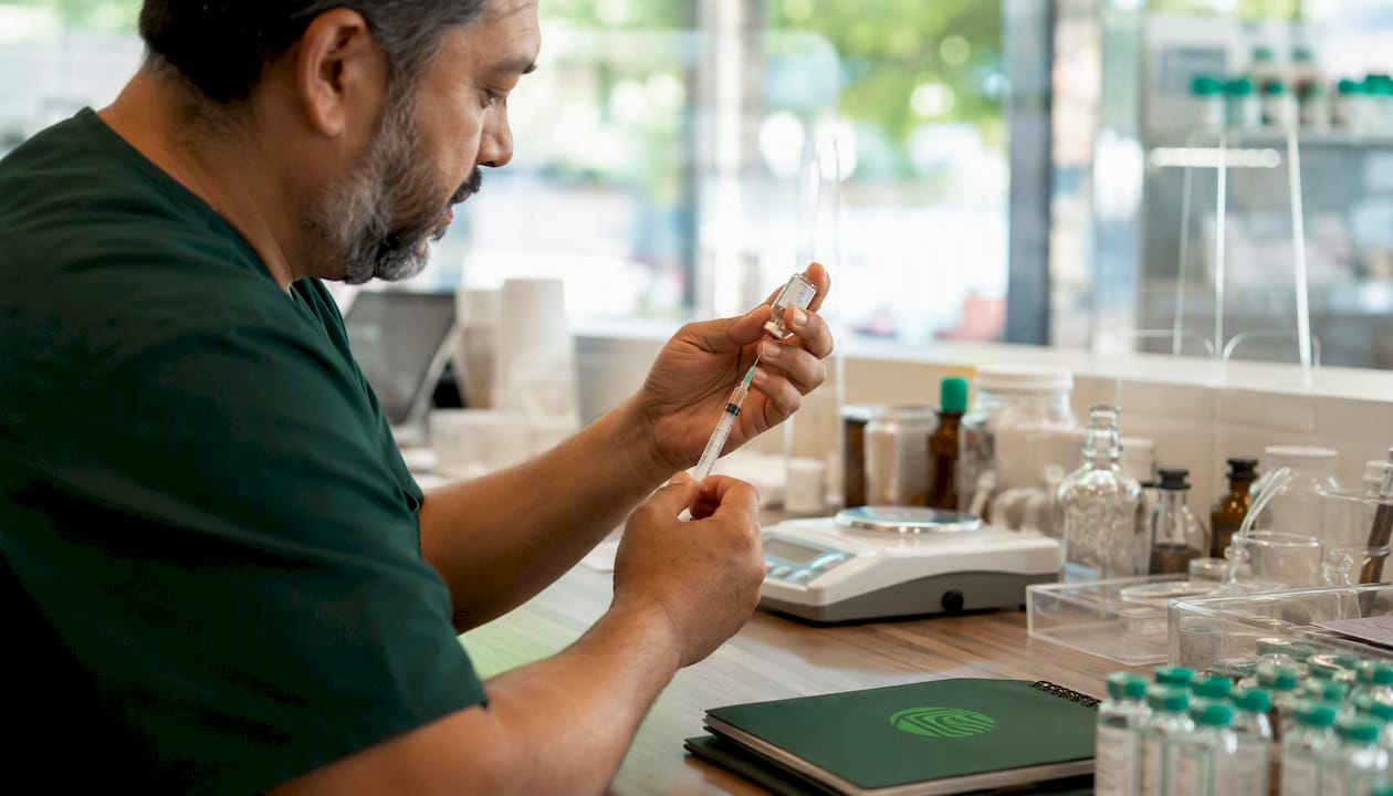 Hands preparing compounded medication in pharmacy