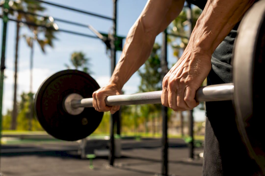 Hands gripping barbell during strength training