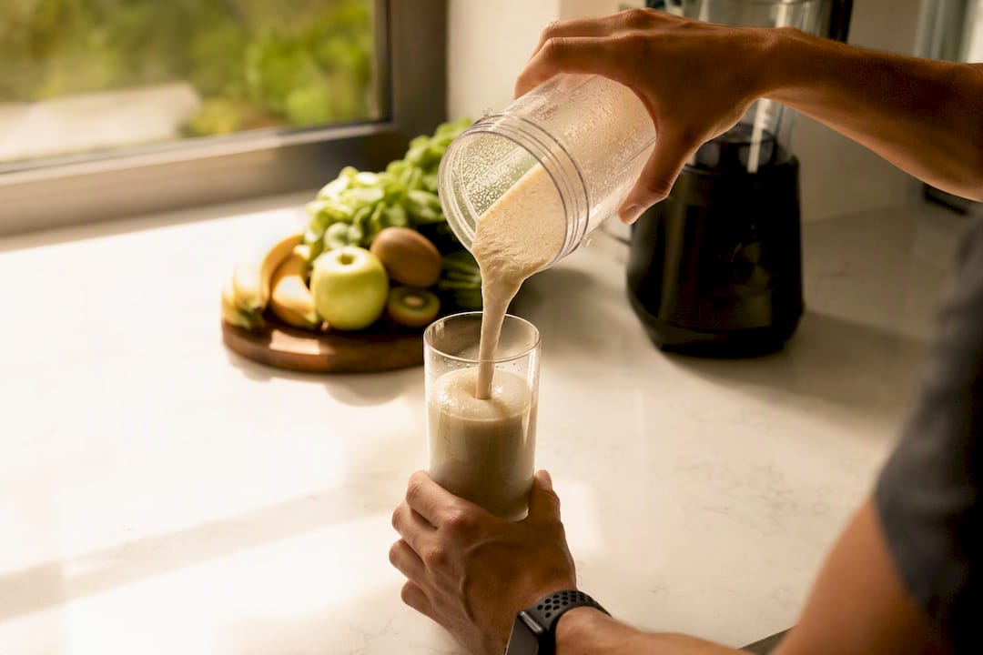 Hands holding glass with liquid protein shake