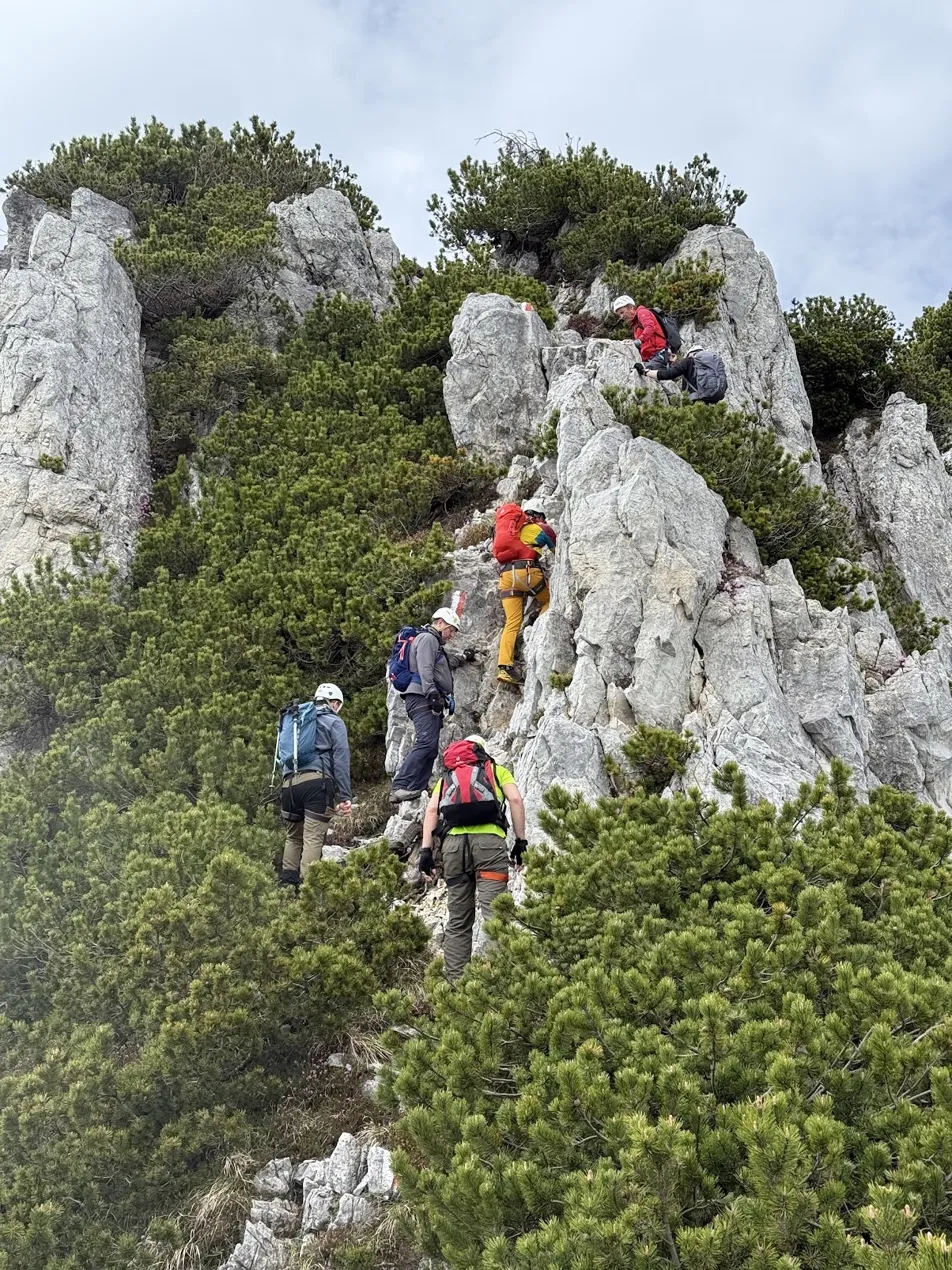 Geeks Go Peaks group scrambling up a rocky ridge in helmets — guides leading from front and rear