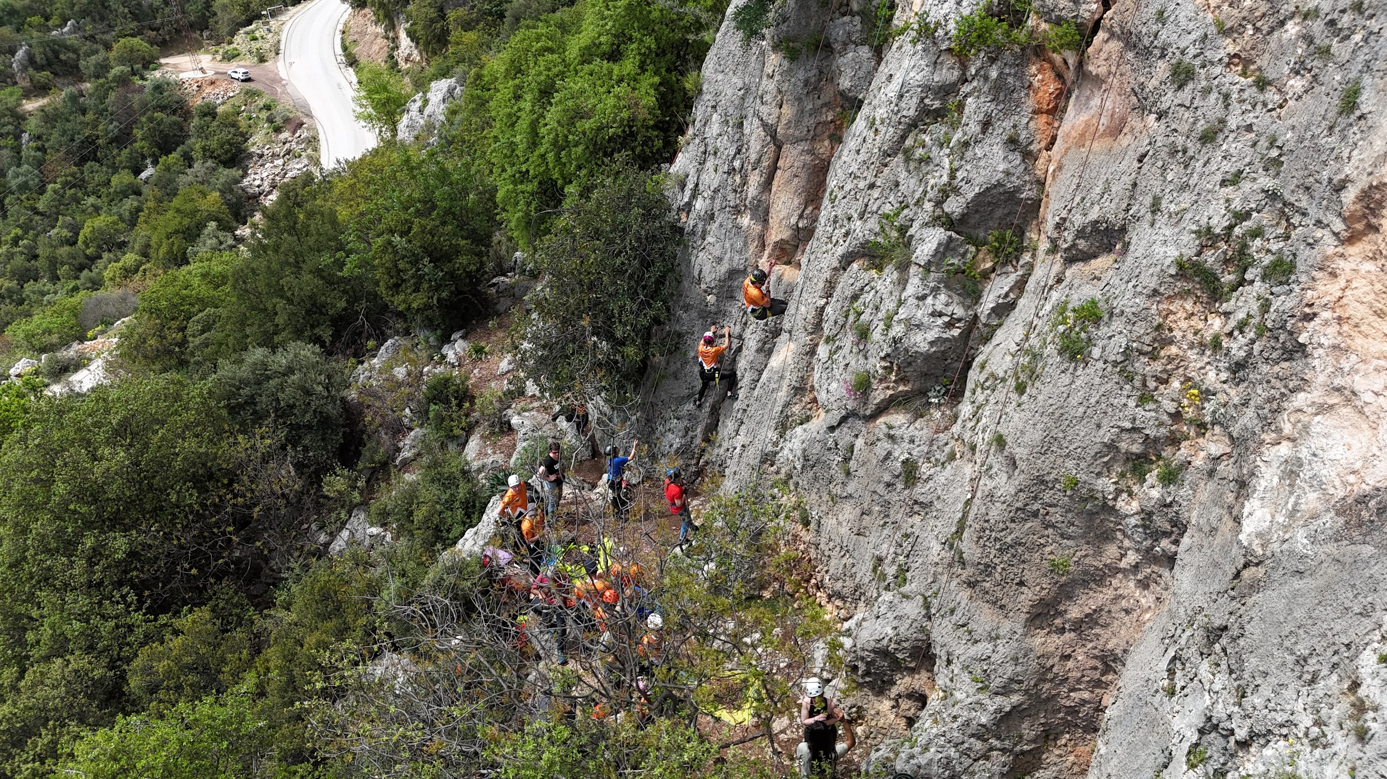 Percona team member climbing a limestone sport route at Geyikbayiri, guide belaying below