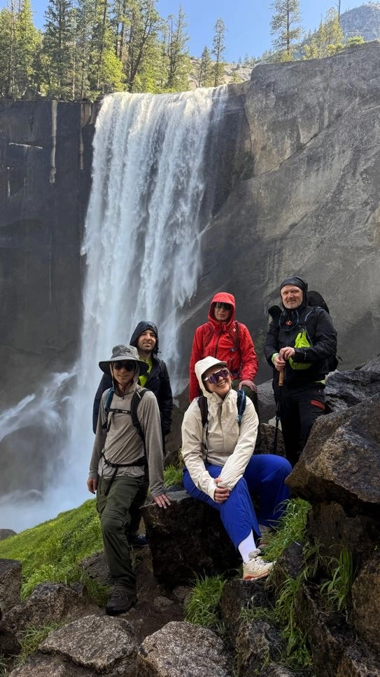 Group members posing in front of the waterfall