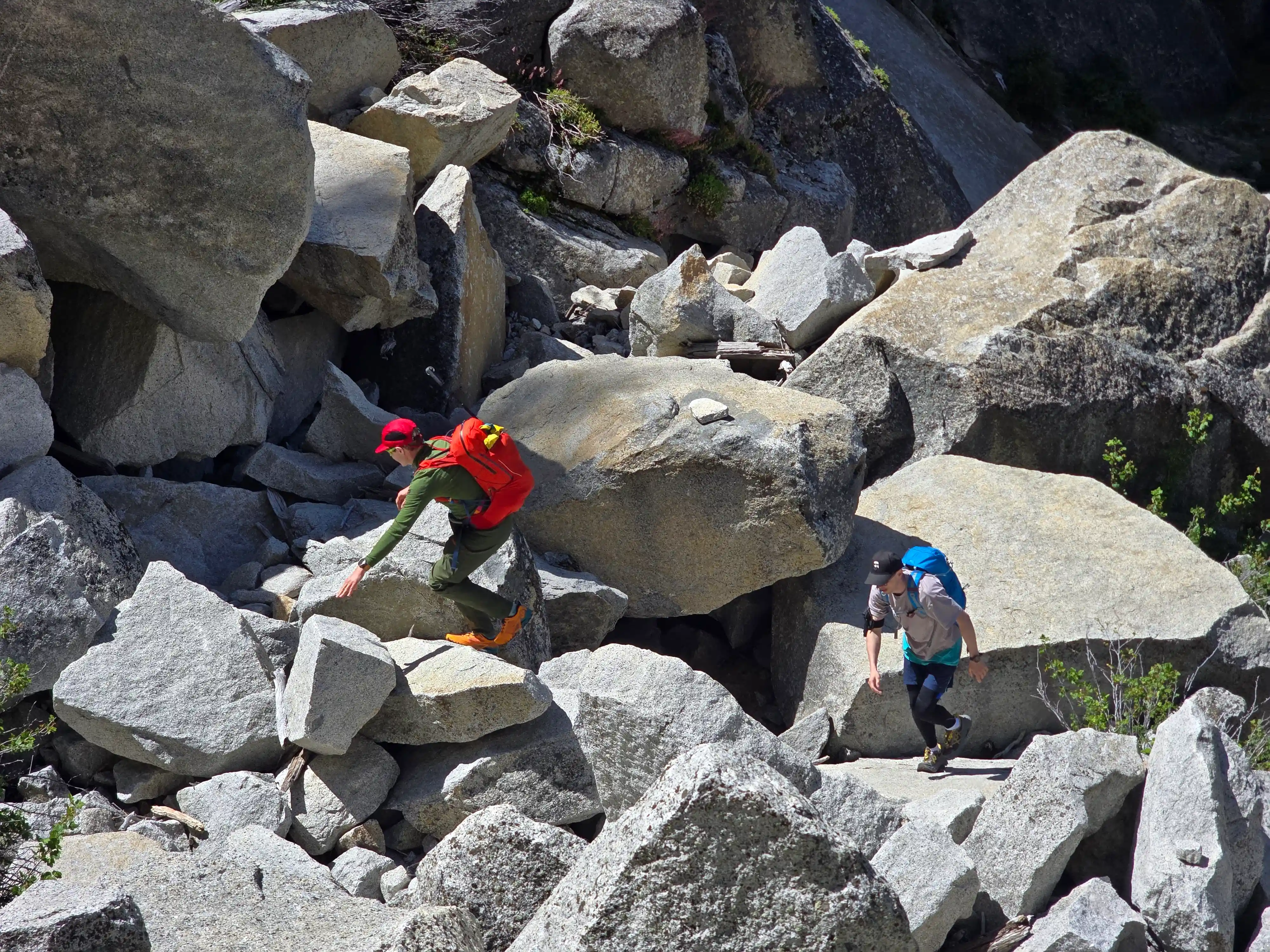 Two group members climbing on granite rocks as a shortcut between falls