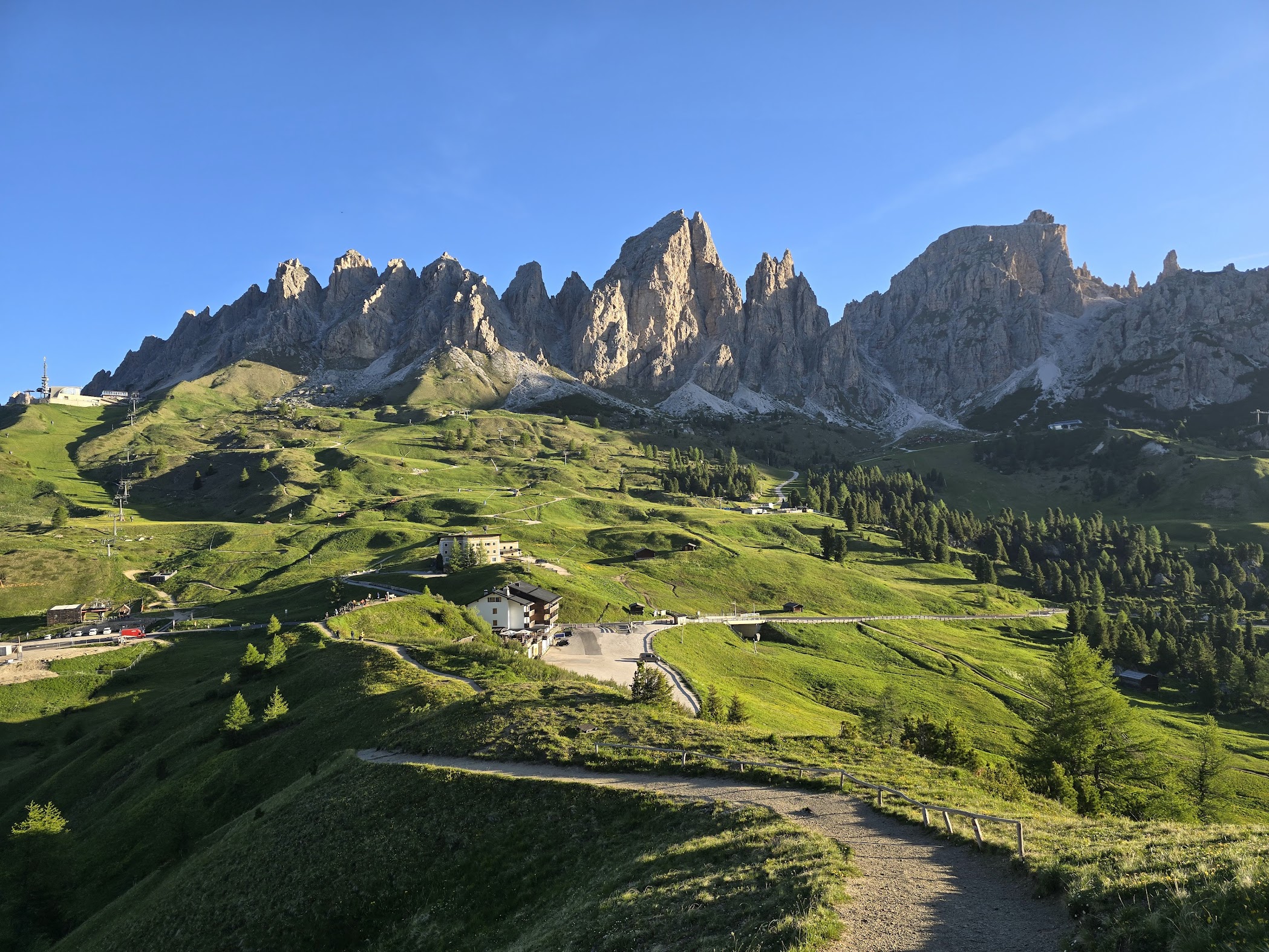 Green trail winding toward the jagged peaks above Passo Gardena, Dolomites