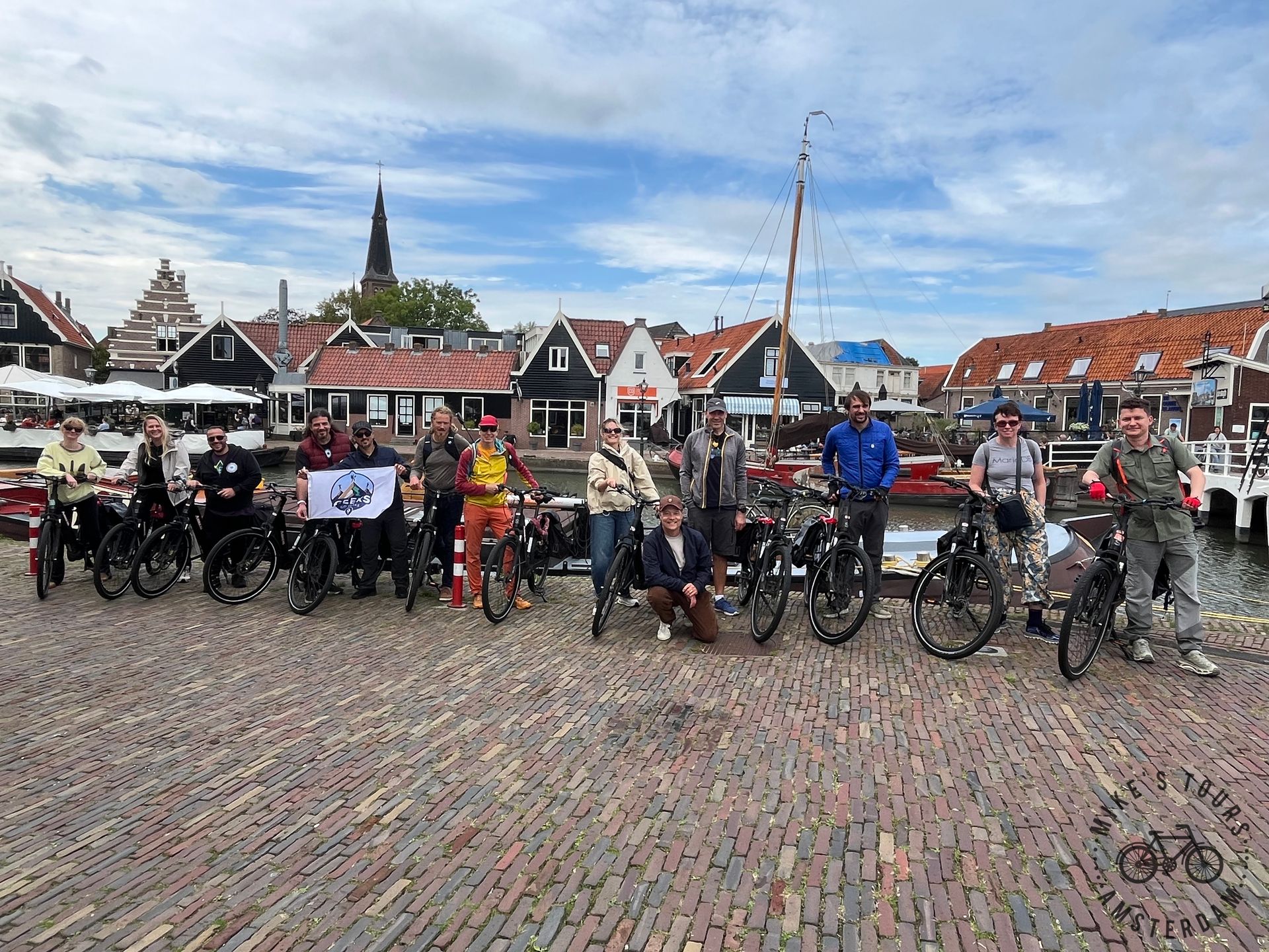 The Geeks Go Peaks group with e-bikes at a Waterland harbor town