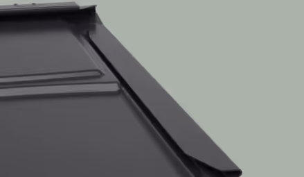 Close-up of a dark gray metal roof panel showing its interlocking edges and raised seams.